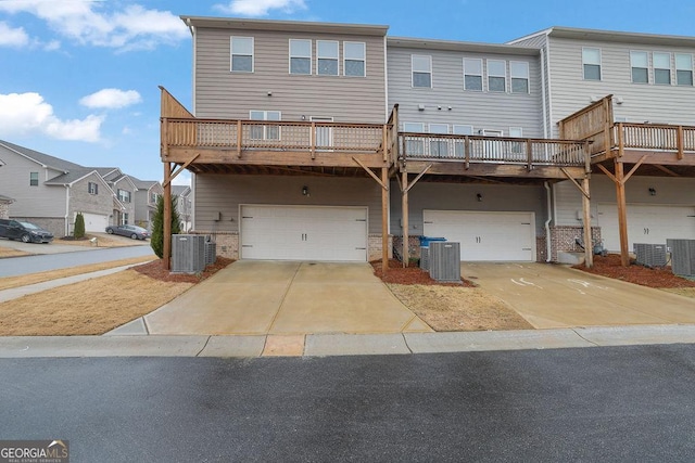 view of front of home with a garage and central AC