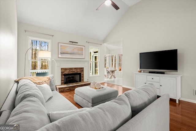 living room featuring ceiling fan, high vaulted ceiling, dark hardwood / wood-style floors, and a fireplace