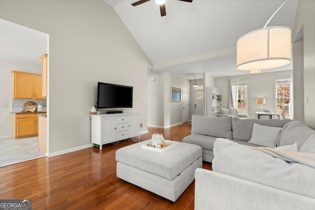 living room featuring wood-type flooring, ceiling fan, and high vaulted ceiling