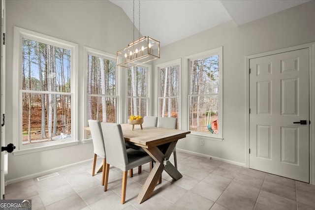 sunroom / solarium with vaulted ceiling, a healthy amount of sunlight, and a chandelier