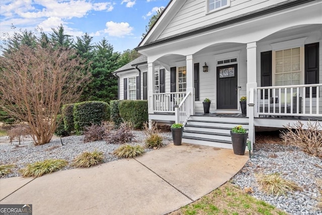 view of exterior entry featuring covered porch