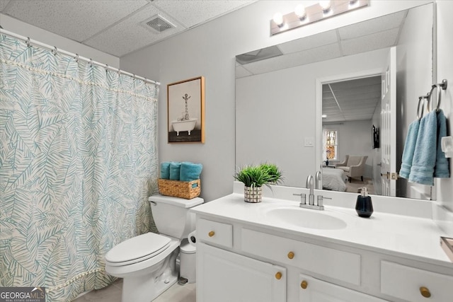 bathroom with vanity, a paneled ceiling, and toilet