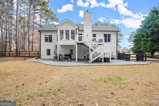 rear view of property with a yard, a patio area, and a deck