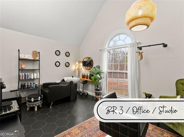 living room with dark tile patterned flooring and high vaulted ceiling