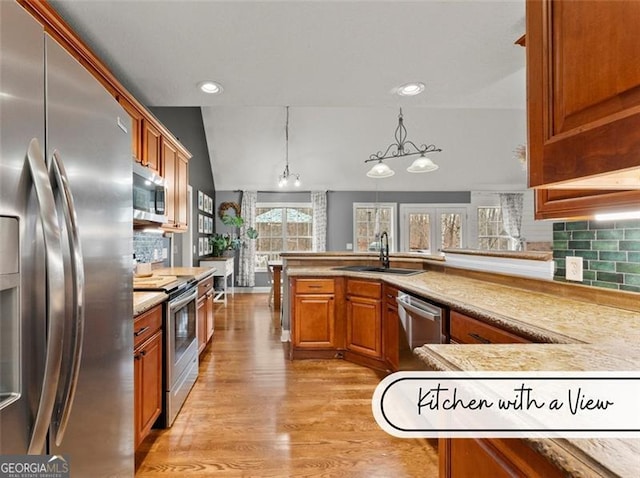 kitchen with sink, kitchen peninsula, pendant lighting, stainless steel appliances, and decorative backsplash