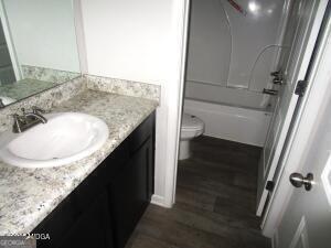 full bathroom featuring shower / bathtub combination, vanity, toilet, and wood-type flooring