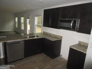 kitchen featuring appliances with stainless steel finishes, sink, and wood-type flooring