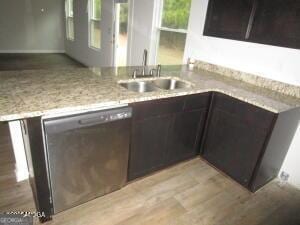 kitchen featuring dark brown cabinetry, sink, light stone counters, and stainless steel dishwasher