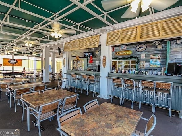 interior space with coffered ceiling, ceiling fan, and indoor bar