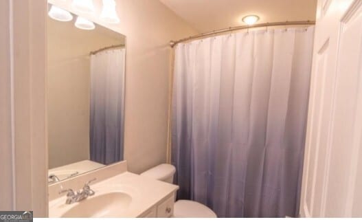 bathroom with vanity, a shower with curtain, and toilet