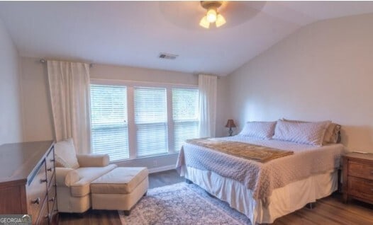 bedroom featuring hardwood / wood-style floors, vaulted ceiling, and ceiling fan