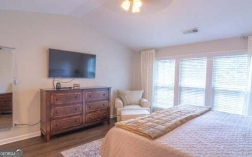 bedroom featuring lofted ceiling, dark hardwood / wood-style flooring, and ceiling fan