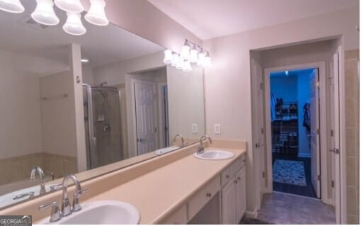 bathroom featuring a shower with door and vanity