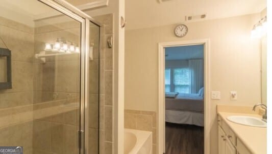 bathroom featuring vanity, plus walk in shower, and hardwood / wood-style floors