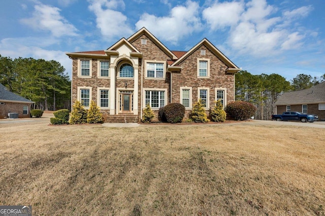 view of front of property with central AC unit and a front lawn