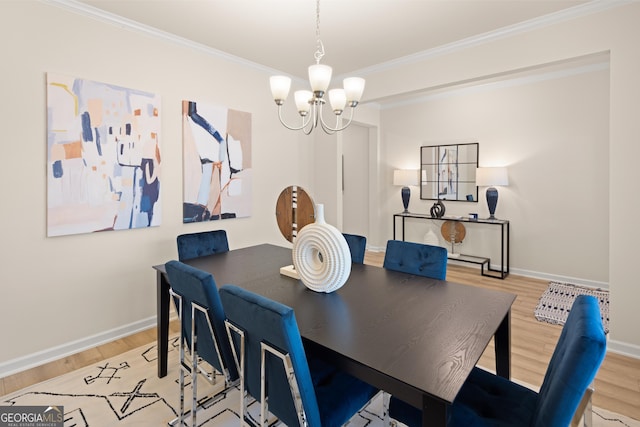 dining space with ornamental molding, a chandelier, and light wood-type flooring