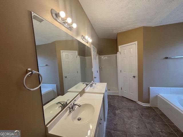 bathroom featuring vanity, a bathtub, and a textured ceiling