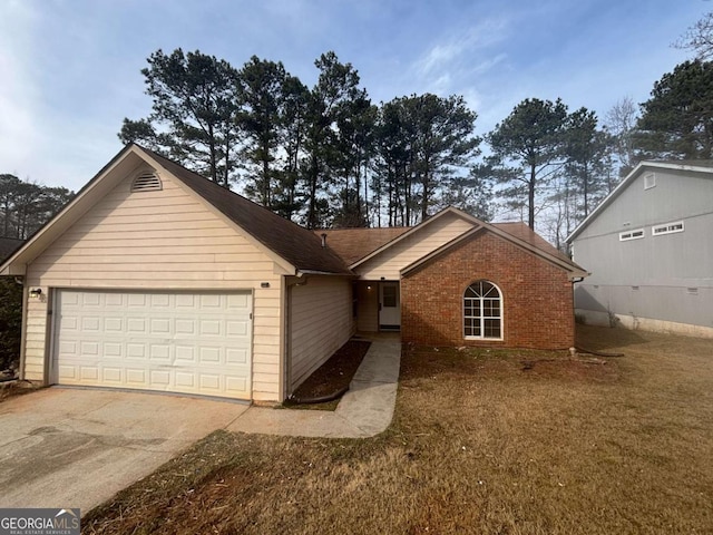 ranch-style home featuring a garage and a front lawn