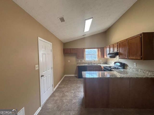 kitchen with lofted ceiling, sink, dark stone counters, kitchen peninsula, and black gas stove