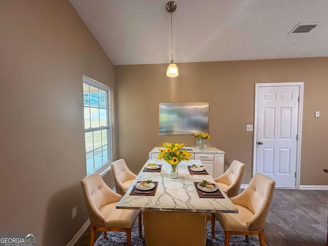 dining space featuring vaulted ceiling