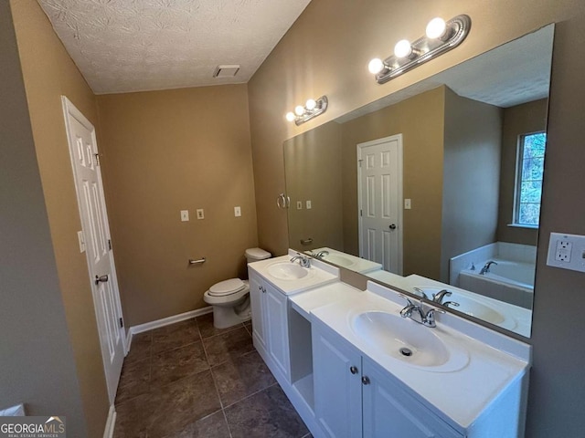 bathroom featuring vanity, a textured ceiling, a tub to relax in, tile patterned floors, and toilet