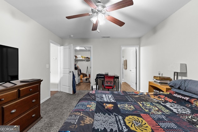 bedroom featuring ceiling fan, a walk in closet, carpet flooring, and a closet