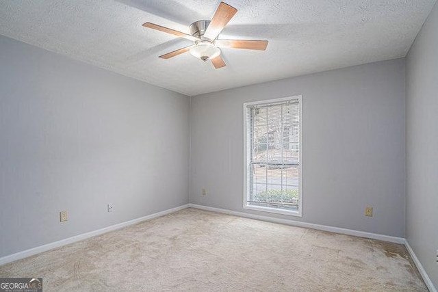 carpeted spare room featuring a textured ceiling and ceiling fan