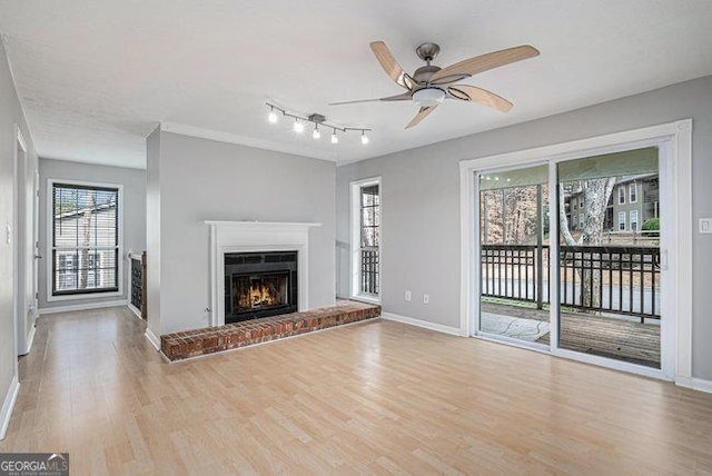 unfurnished living room featuring ceiling fan, a fireplace, and light hardwood / wood-style floors