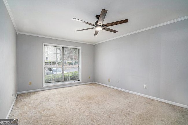 spare room featuring ornamental molding, light colored carpet, and ceiling fan