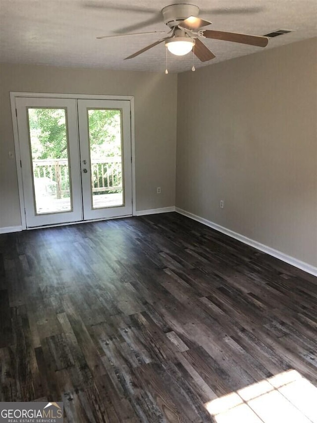 empty room with french doors, ceiling fan, and dark hardwood / wood-style floors