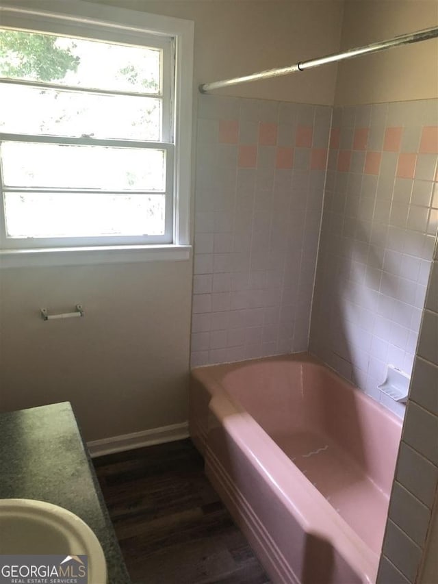 bathroom featuring vanity, hardwood / wood-style floors, and tiled shower / bath