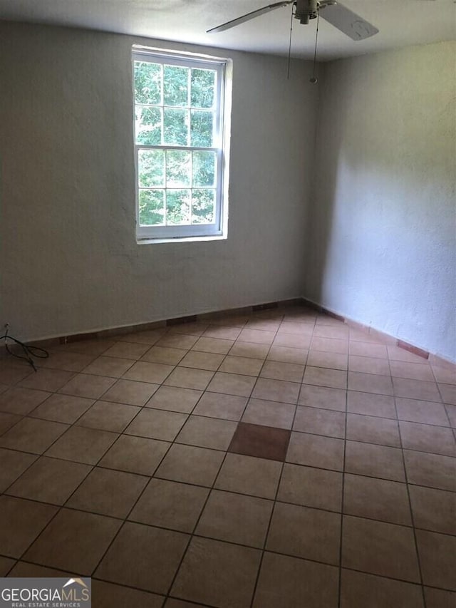 tiled empty room with ceiling fan