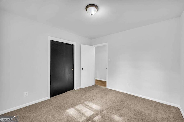 unfurnished bedroom with carpet floors and a closet