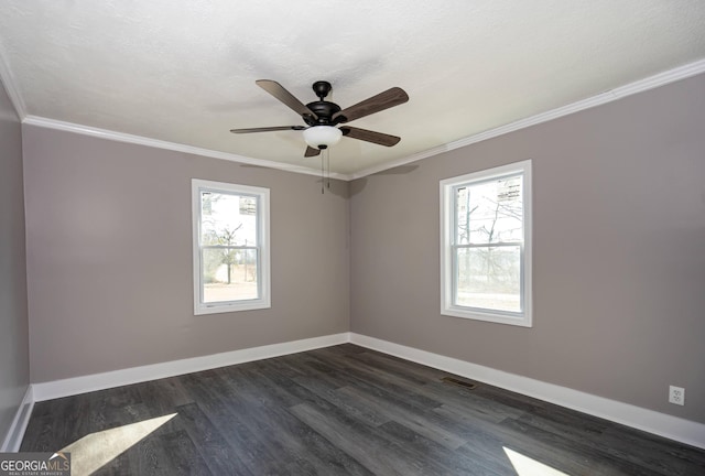 empty room featuring ornamental molding, a healthy amount of sunlight, a textured ceiling, and dark hardwood / wood-style floors