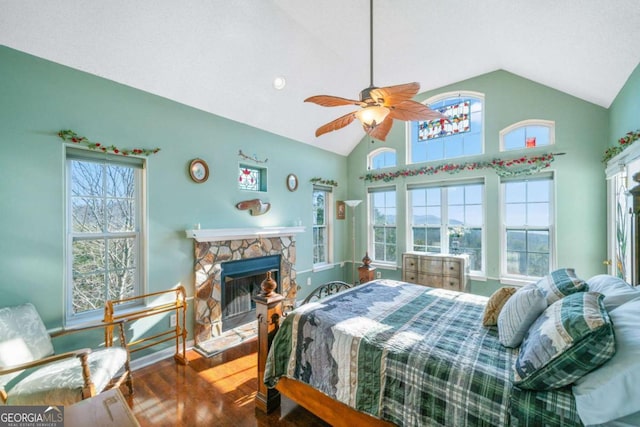 bedroom with multiple windows, a fireplace, lofted ceiling, and wood-type flooring