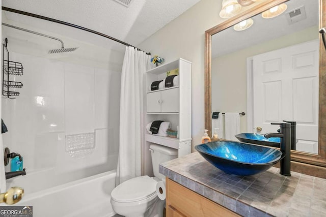 full bathroom featuring vanity, toilet, shower / tub combo, and a textured ceiling