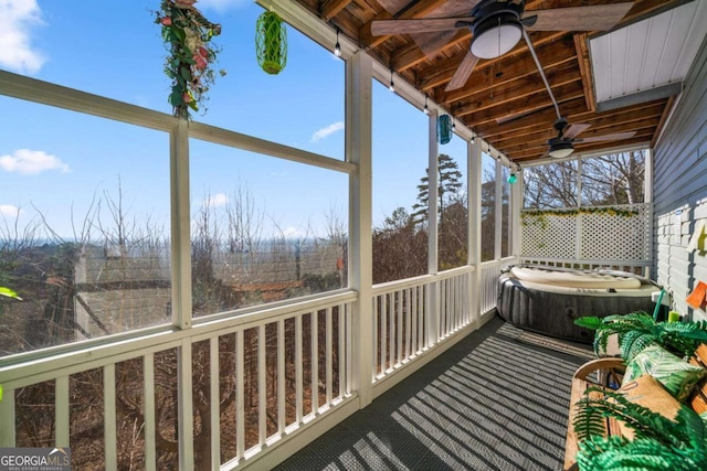 deck with ceiling fan, a hot tub, and a sunroom