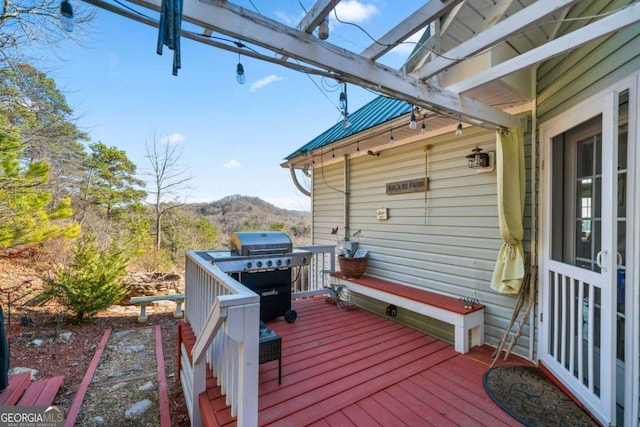 deck with a grill and a mountain view