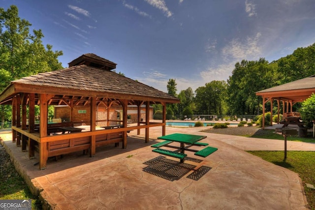 view of community featuring a gazebo, a swimming pool, and a patio