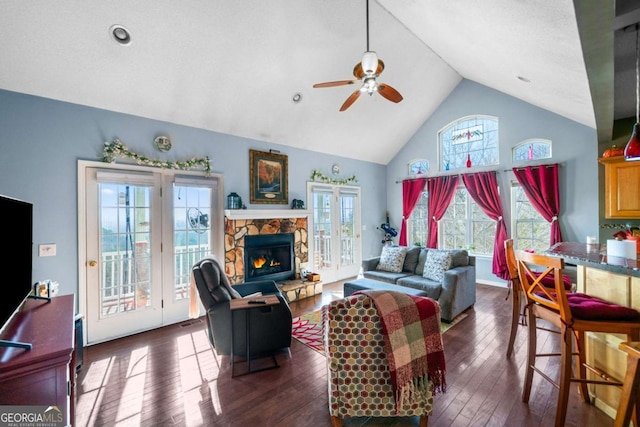 living room with a stone fireplace, high vaulted ceiling, dark hardwood / wood-style floors, and ceiling fan