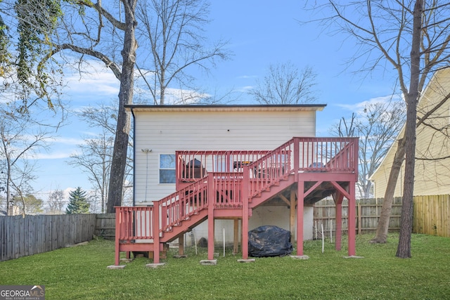 rear view of property featuring a wooden deck and a yard