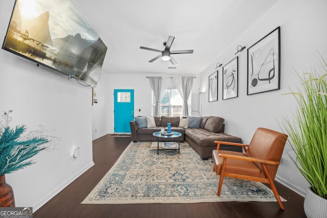 living room featuring dark wood-type flooring and ceiling fan