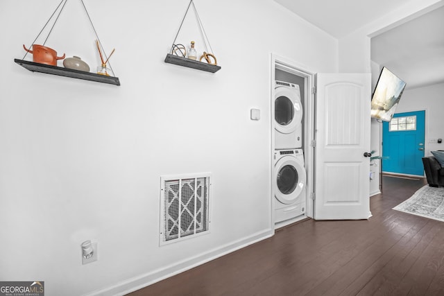 laundry room featuring dark hardwood / wood-style floors and stacked washer and clothes dryer