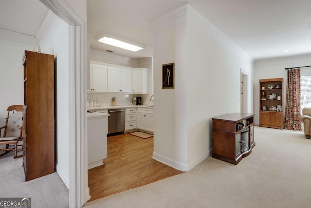 hallway featuring crown molding, light colored carpet, and sink