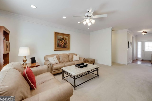 carpeted living room featuring ornamental molding and ceiling fan