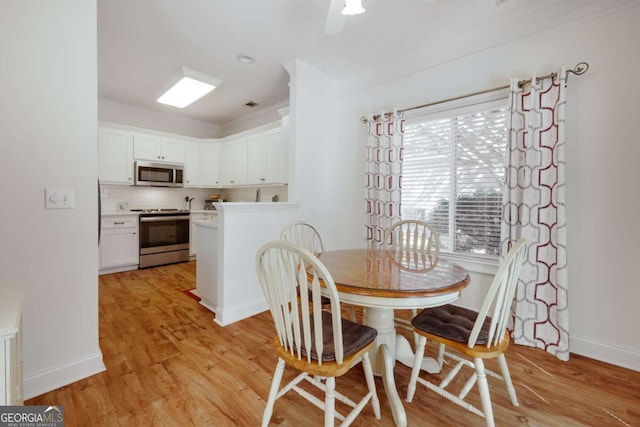 dining space with light hardwood / wood-style flooring and ornamental molding