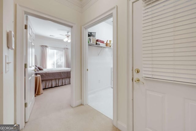 hall with crown molding and light colored carpet