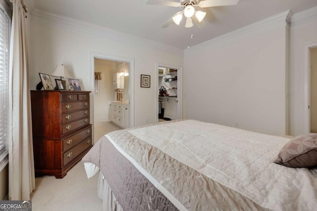 bedroom featuring connected bathroom, a spacious closet, crown molding, light carpet, and a closet