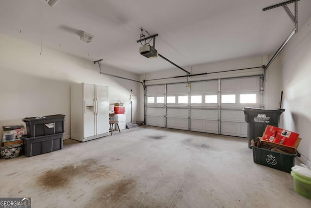 garage featuring a garage door opener and white fridge with ice dispenser