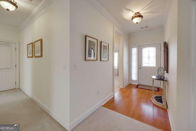 entrance foyer with ornamental molding and light wood-type flooring